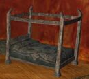 A pristine canopied briarwood king bed