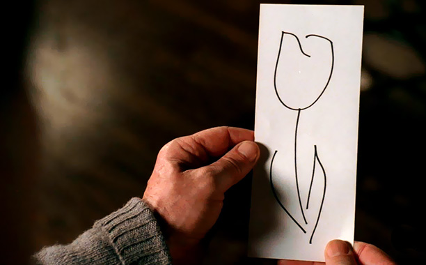 Walter holding a drawing of a white tulip.