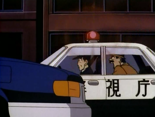 Archivo:Megure en un coche policía.png