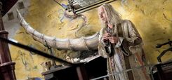 Xenophilius Lovegood standing on stairs in house