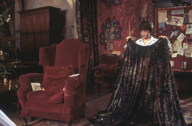 File:HarryHoldingInvisibilityCloakInGryffindorCommonRoom.png