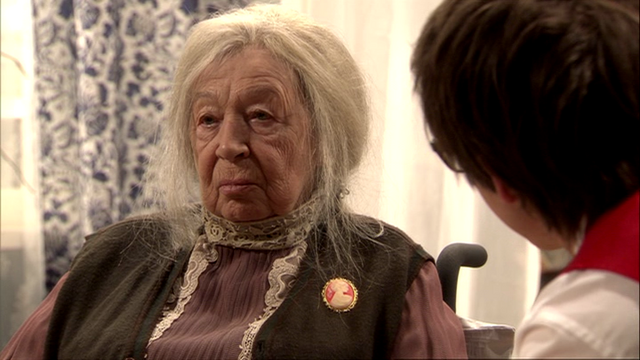 Datei:Tom befragt Frau Hennings zur Postkarte.png
