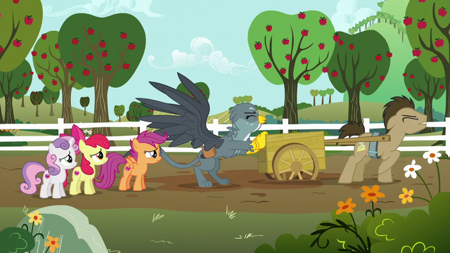 File:Gabby pushes Dr. Hooves' cart out of the mud S6E19.png