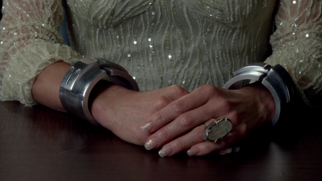 Fichier:4x07 Ingrid menottes magiques poste de police interrogatoire bague imposante table.png