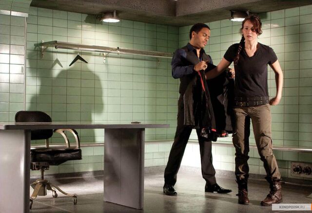 Archivo:Cinna y Katniss en la sala de lanzamiento.jpg