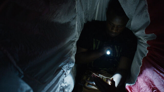 File:Little Thing 1x08 Mohamad in a tent looking at a photo.jpg
